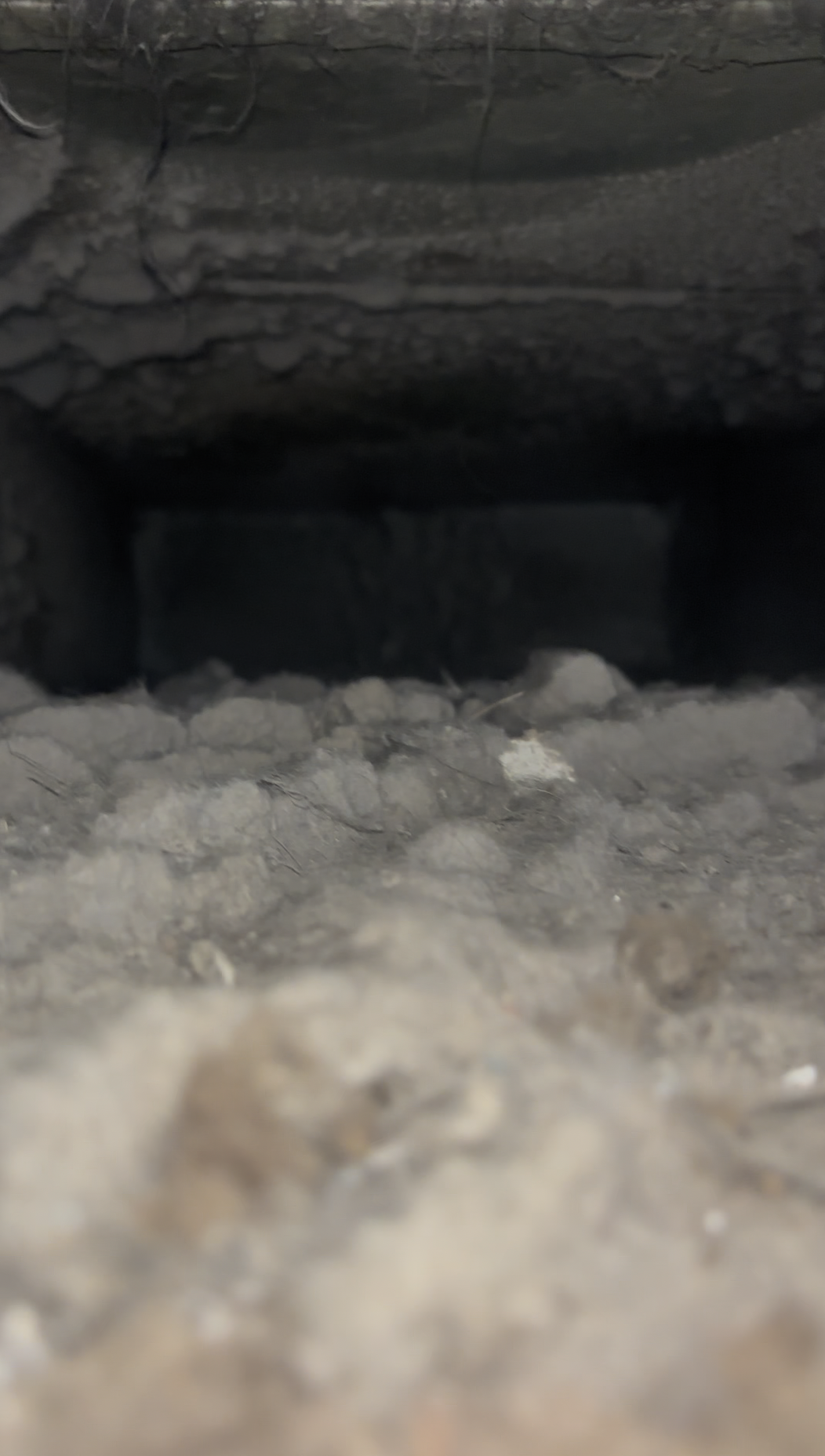 Inside a return duct packed with dust and lint, before cleaning